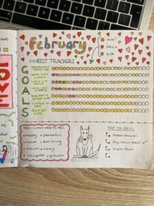bullet journal spread for February with healthy goal tracker and to dos, doodle dog at the bottom
